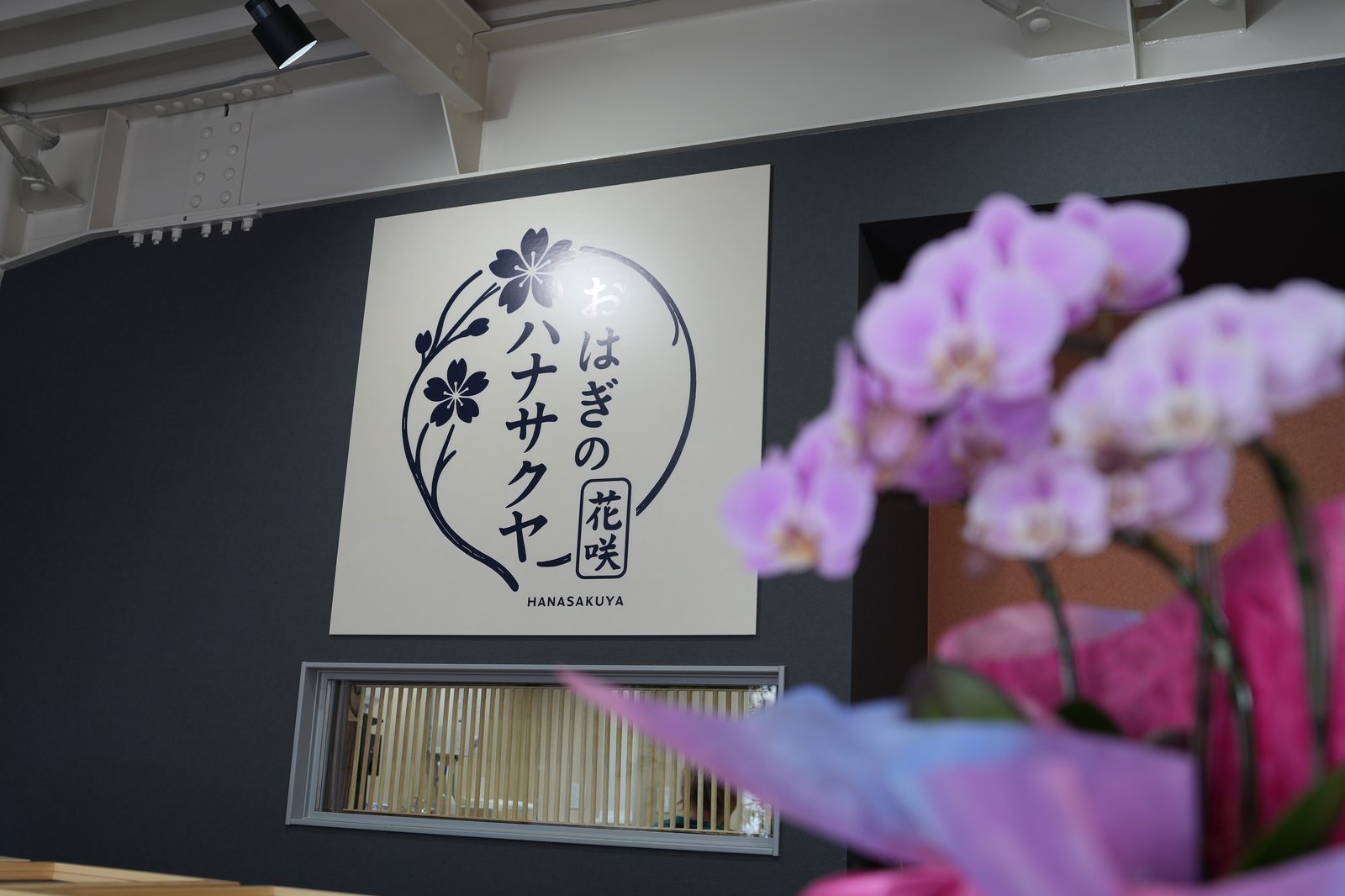 店内のロゴ壁と胡蝶蘭